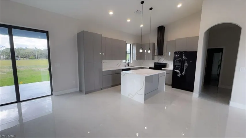Kitchen with modern cabinets, gray cabinetry, fridge, and recessed lighting