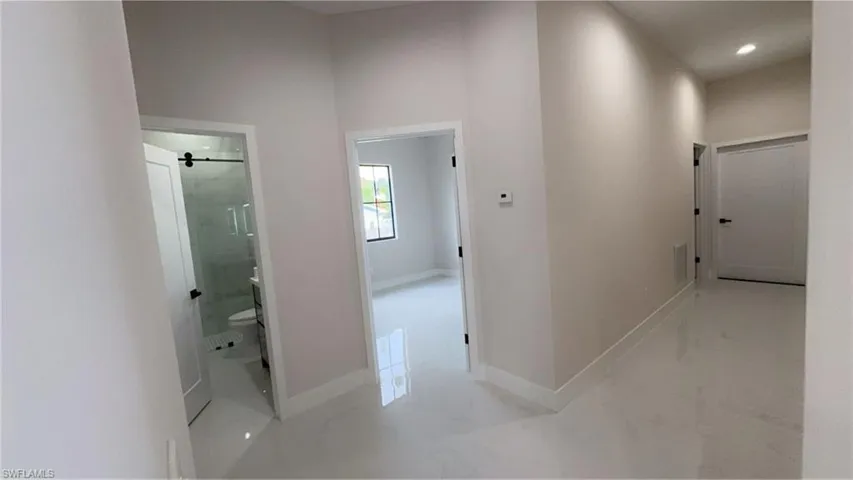 Hall with light marble finish floors and baseboards