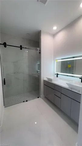 Bathroom featuring a marble finish shower and recessed lighting