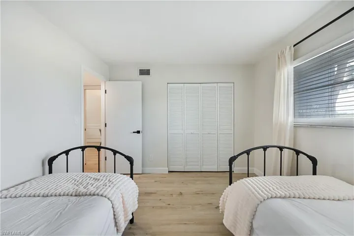 Bedroom with light wood finished floors and a closet