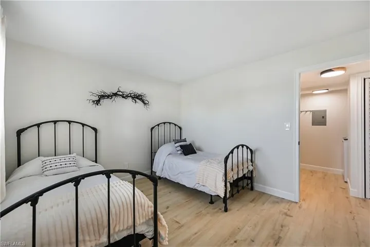 Bedroom with light wood-style floors and electric panel