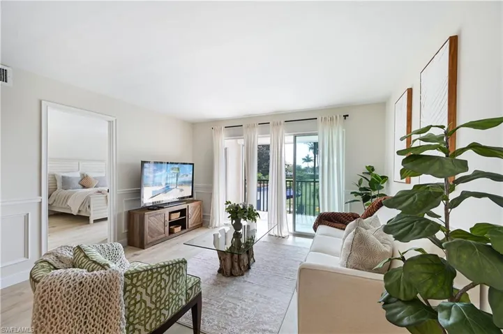 Living area featuring light wood-style floors, wainscoting, and a decorative wall