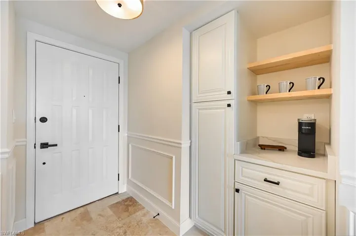 Doorway to outside featuring wainscoting and coffee niche/pantry