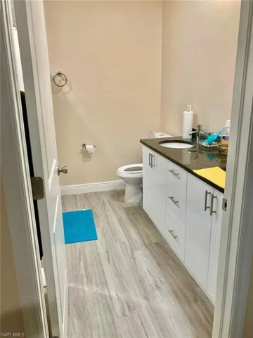 Bathroom featuring wood-type flooring, toilet, and vanity