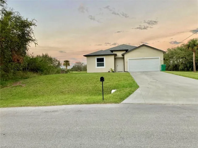 View of front of home featuring a garage and a lawn