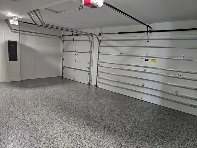 Garage with electric panel and a garage door opener