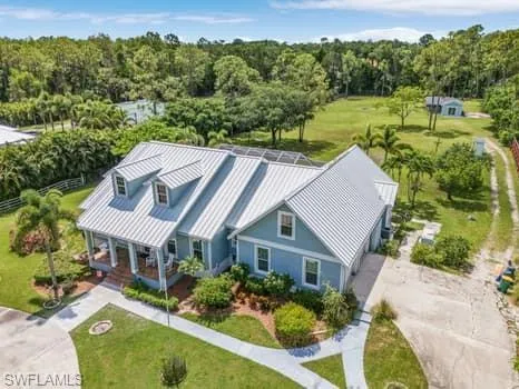 Birds eye view of property with a wooded view