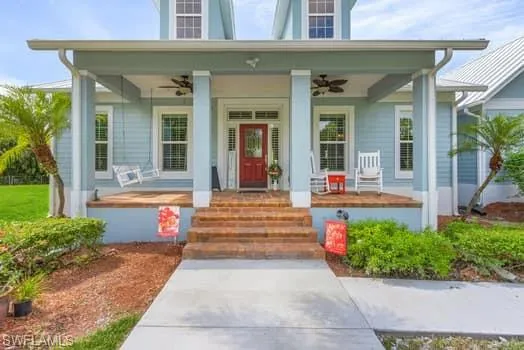 View of exterior entry featuring a porch and a ceiling fan