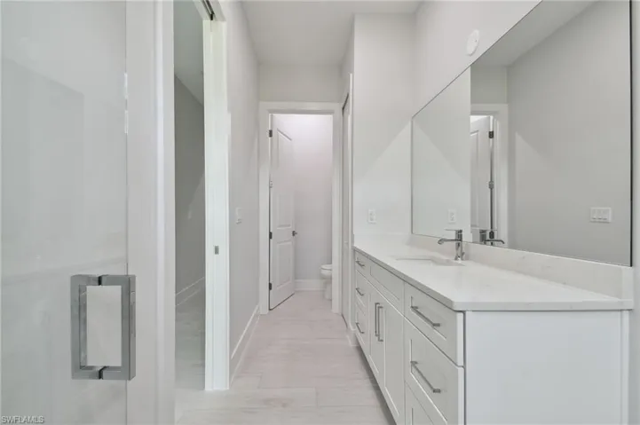 Bathroom featuring hardwood / wood-style floors, vanity, and toilet