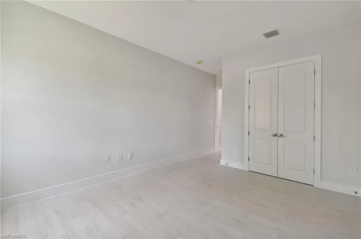 Unfurnished bedroom with a closet and light wood-type flooring