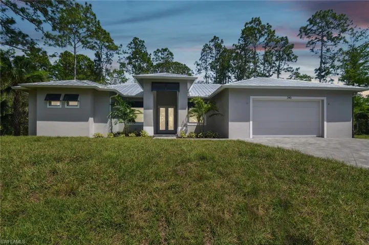 View of front facade featuring a yard and a garage