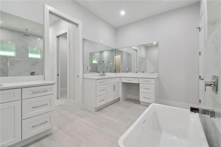 Bathroom featuring vanity and shower with separate bathtub