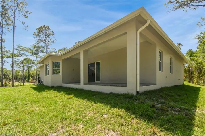 Back of property featuring a lawn