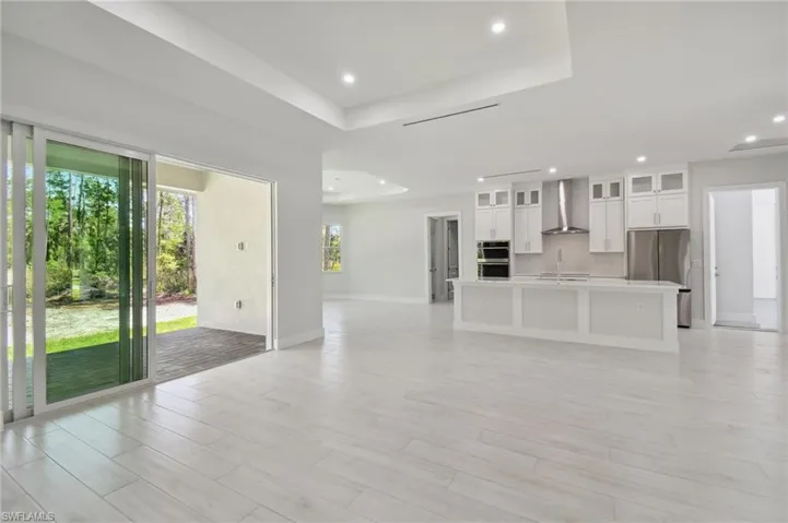 Unfurnished living room with sink and a raised ceiling