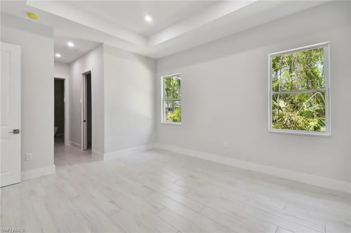 Unfurnished room with light hardwood / wood-style floors and a raised ceiling