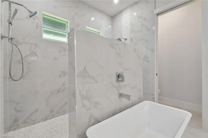 Bathroom featuring toilet and tile walls