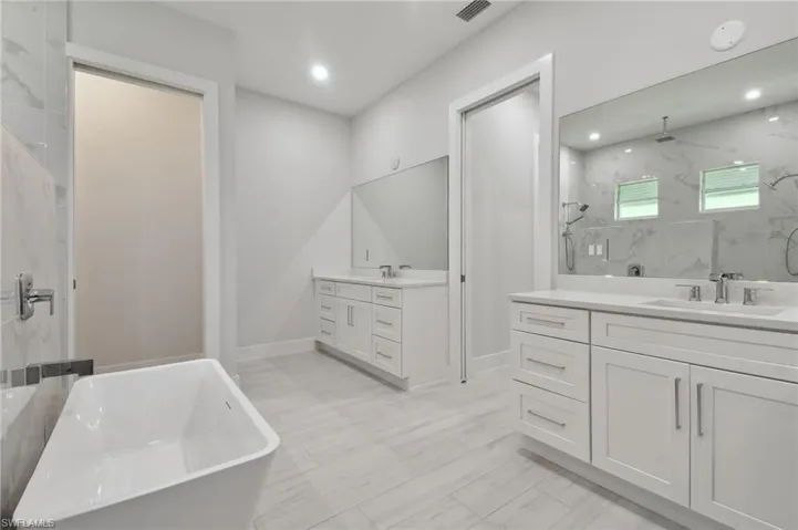 Bathroom with tile floors, independent shower and bath, and double vanity