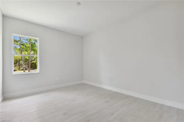 Unfurnished room featuring a healthy amount of sunlight and light hardwood / wood-style flooring