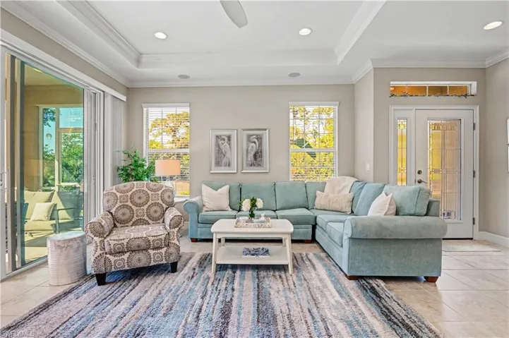 Living room with light tile patterned floors, recessed lighting, plenty of natural light, ornamental molding, and a ceiling fan