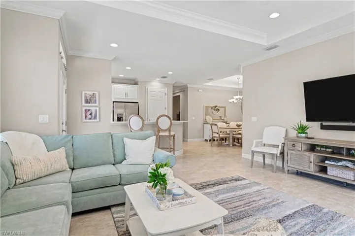 Living room featuring hanging lights and ornamental molding