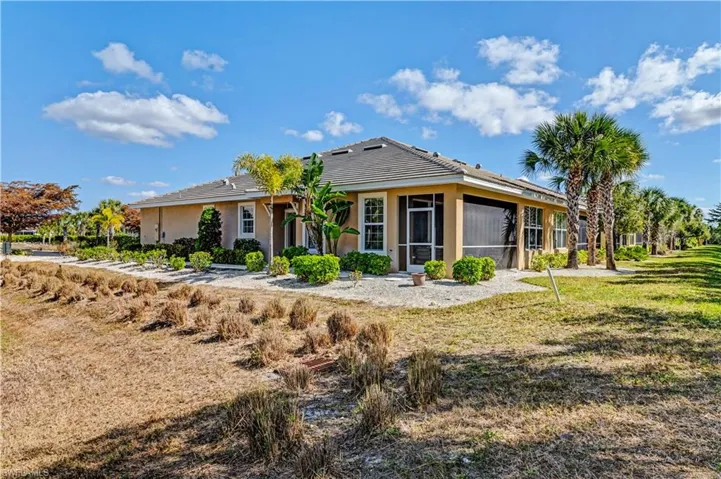 Back of house featuring a sunroom, stucco siding, and a yard