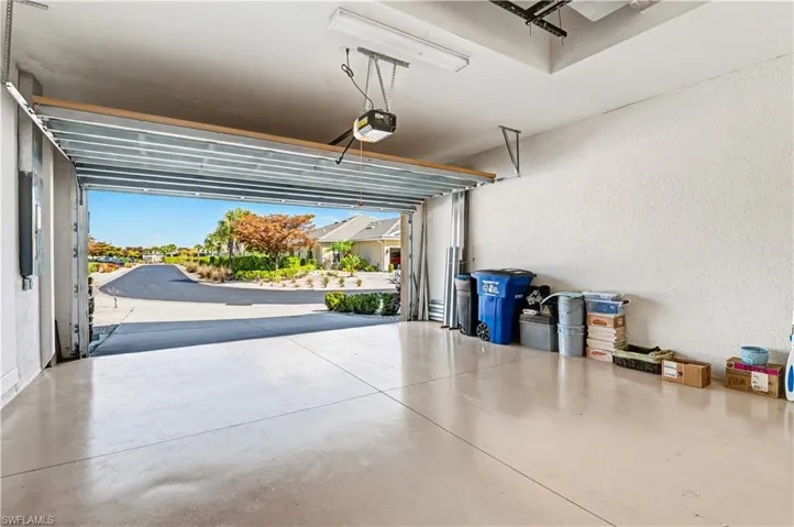 Garage featuring a textured wall and a garage door opener