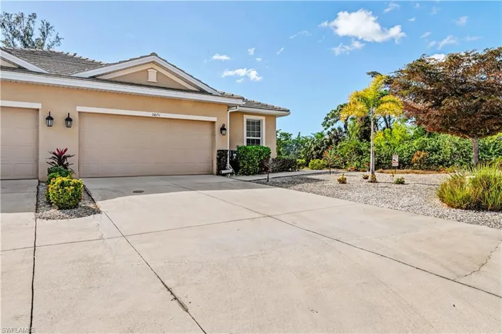 View of front of property with stucco siding, concrete driveway, and an attached garage