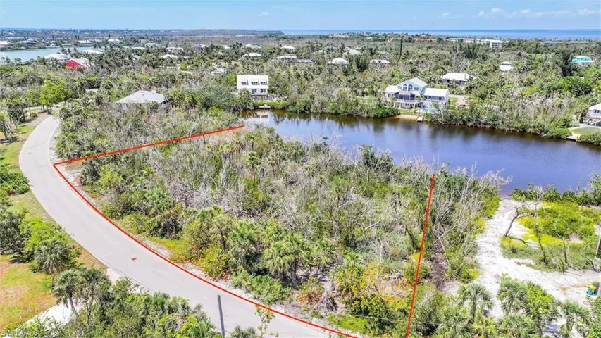 Aerial view of property and surrounding area featuring a large body of water and property boundaries highlighted