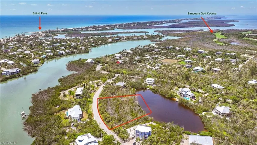 Aerial view of residential area with a nearby body of water and property parcel outlined