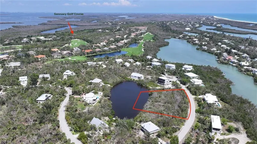 Aerial view of residential area featuring a large body of water and property parcel outlined