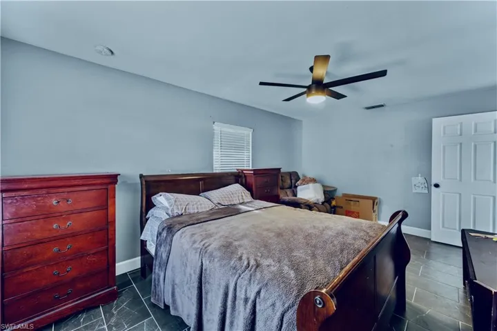 Bedroom with visible vents, baseboards, and ceiling fan