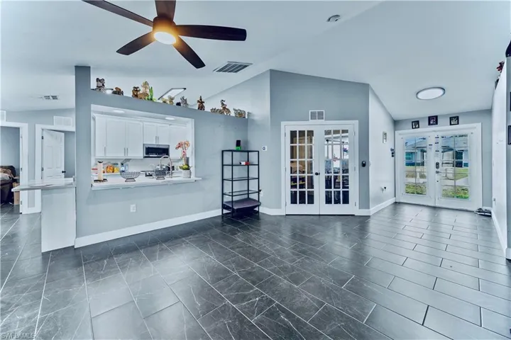 Living room featuring visible vents, baseboards, french doors, and ceiling fan