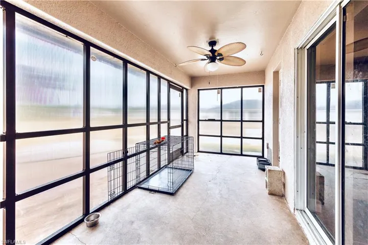 Unfurnished sunroom featuring a water view and ceiling fan