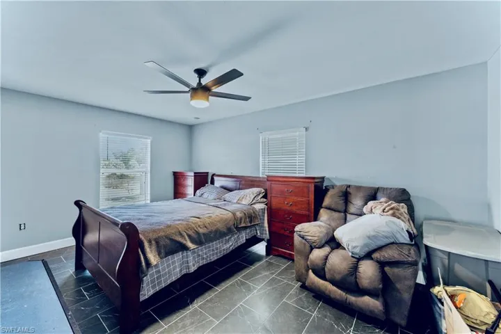 Bedroom featuring ceiling fan and baseboards