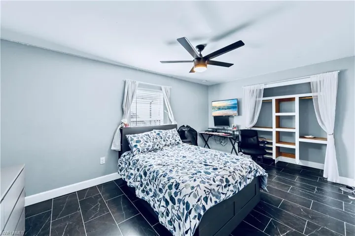 Bedroom with marble finish floor, ceiling fan, and baseboards