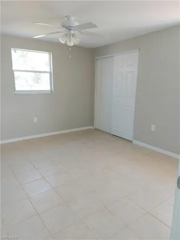 Unfurnished bedroom featuring baseboards, a closet, and a ceiling fan