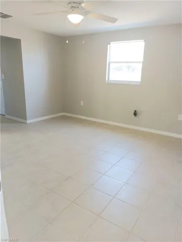 Empty room featuring ceiling fan and baseboards