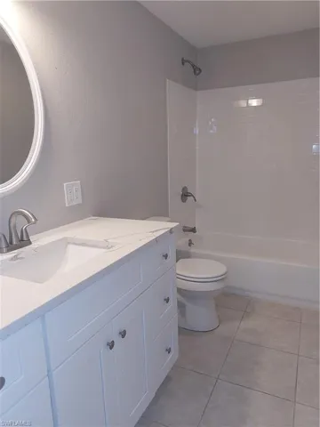 Bathroom featuring vanity, toilet, shower / tub combination, and tile patterned floors