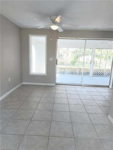 Spare room with a ceiling fan, baseboards, and light tile patterned floors