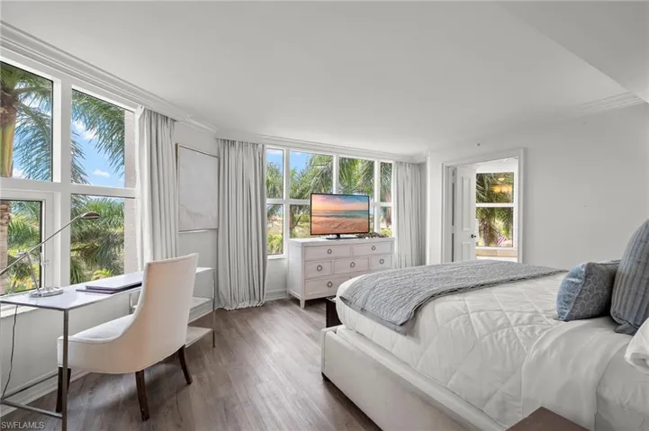 Primary ensuite with King size bed, plenty of space , closet with mirrored doors, and lovely palm tree views out all of the windows