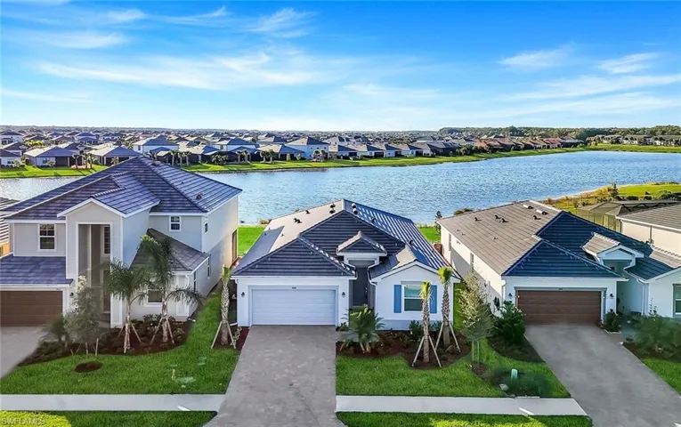 View of front of house featuring a water view, decorative driveway, and stucco siding