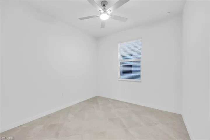 Unfurnished room with baseboards and a ceiling fan