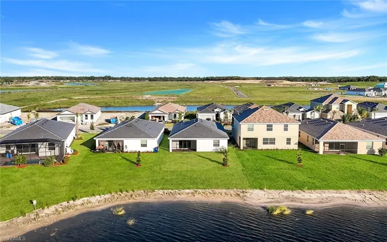 Aerial perspective of suburban area featuring a nearby body of water