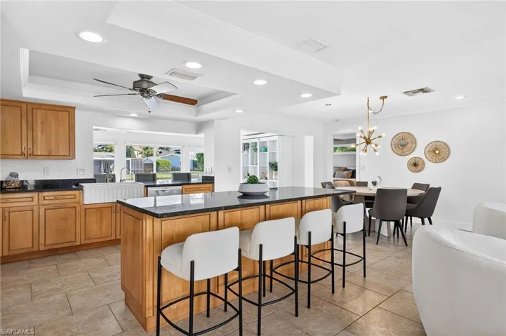 Kitchen featuring crown molding, a kitchen bar, a center island, wood finish cabinetry, and open floor plan
