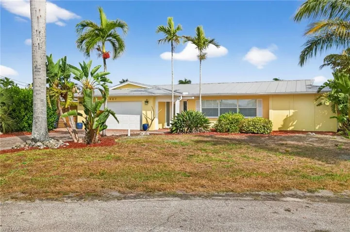 View of front of house featuring an attached garage, a front lawn, and stucco siding
