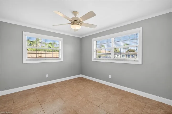 Empty room with ornamental molding and a ceiling fan