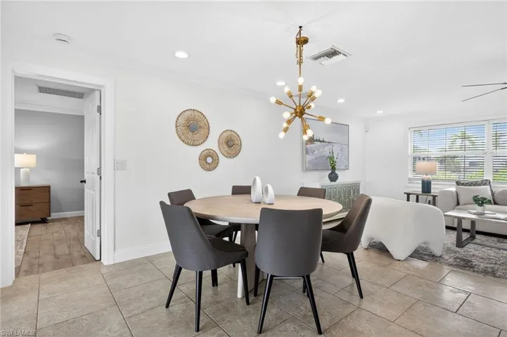 Dining area featuring hanging lights and crown molding