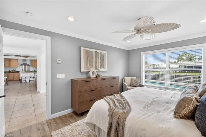 Bedroom with ornamental molding, light wood-type flooring, recessed lighting, and ceiling fan