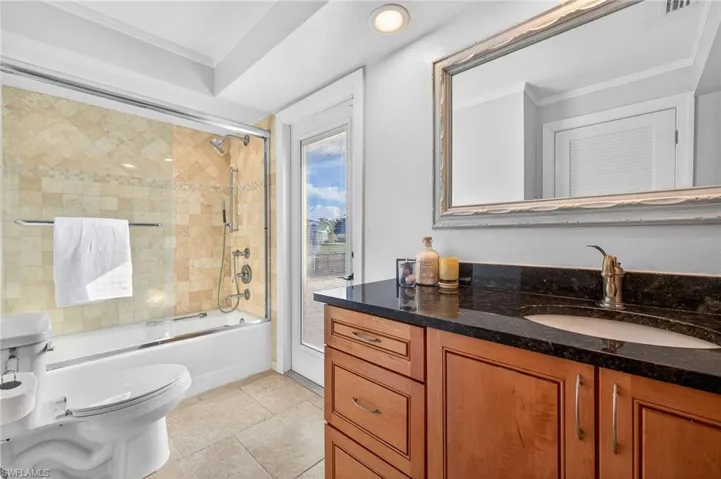 Bathroom with vanity, ornamental molding, bath / shower combo with glass door, recessed lighting, and light tile patterned floors