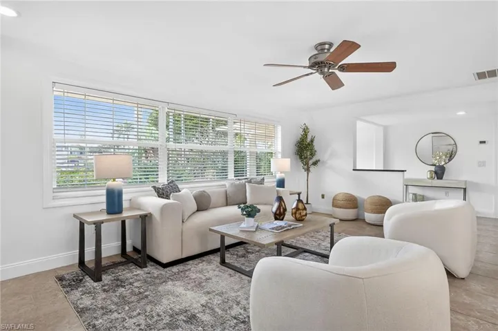 Living room featuring a ceiling fan, ornamental molding, and recessed lighting